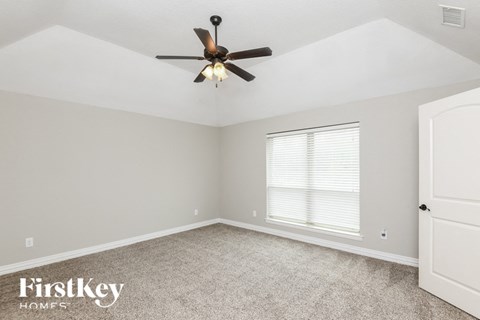 a bedroom with a ceiling fan and a window