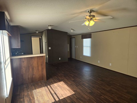 A room with wooden floors and a ceiling fan.