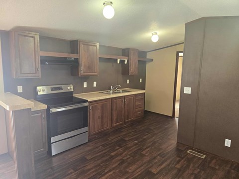 A kitchen with wooden cabinets and a stainless steel oven.