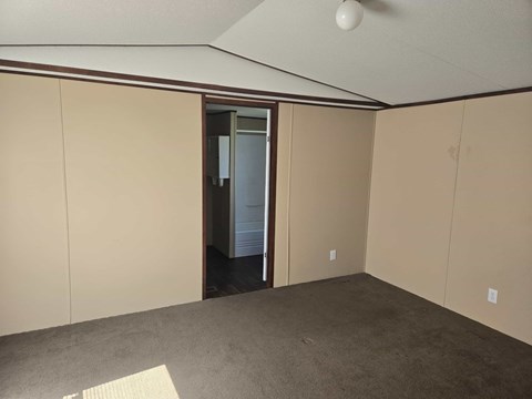 A room with a carpeted floor and a ceiling fan.