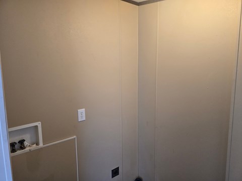 A white door with a light switch on the wall.