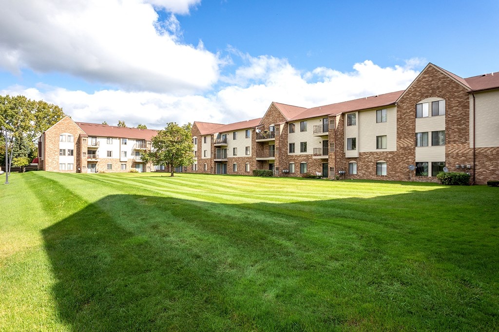 the outlook of an apartment complex with a green lawn