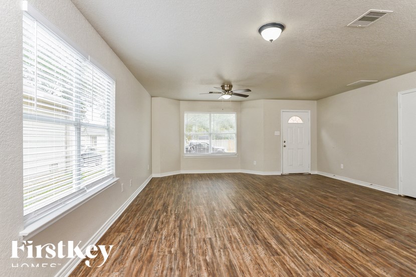 A room with wooden floors and a ceiling fan.