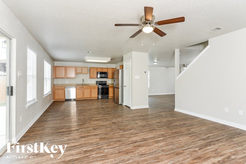 A spacious room with a ceiling fan and wooden flooring.