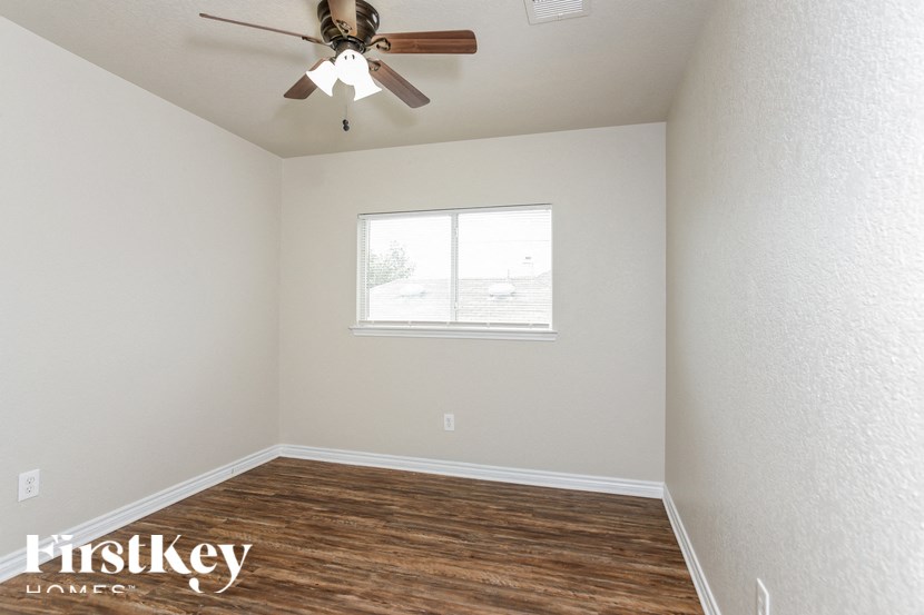 A room with a ceiling fan and a window.