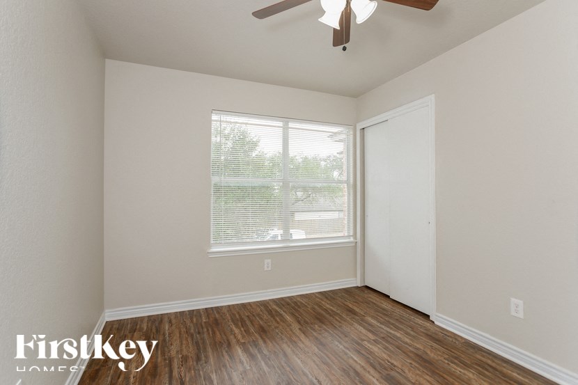 A room with a window and a ceiling fan.