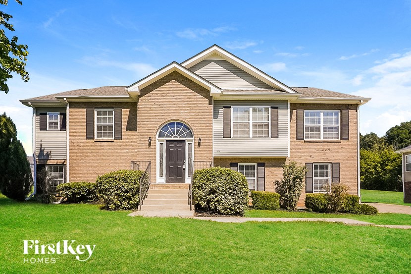 a suburban house with a green lawn and a blue sky