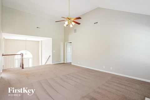 a clean empty living room with a ceiling fan