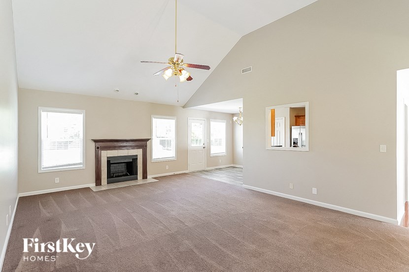 a living room with a fireplace and a ceiling fan