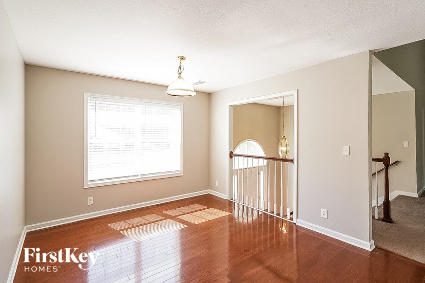 a living room with a hard wood floor and a window and a staircase
