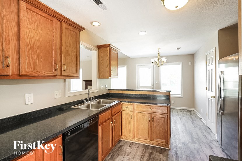 a kitchen with wooden cabinets and black counter tops and a sink