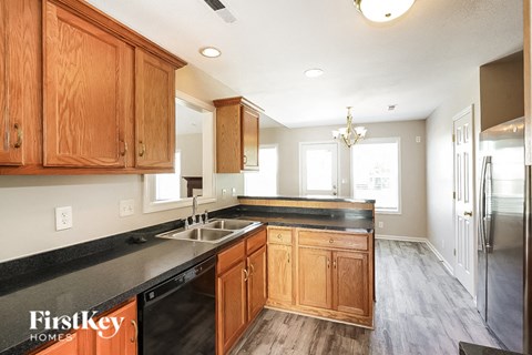 a kitchen with wooden cabinets and black counter tops and a sink