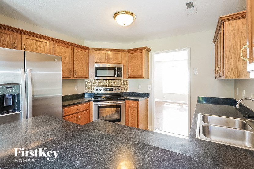 a kitchen with wood cabinets and stainless steel appliances and granite counter tops