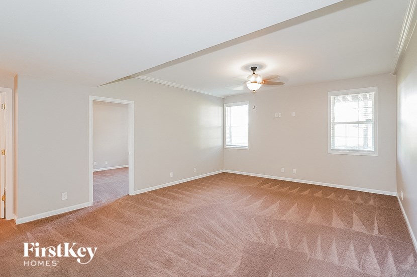 the living room of an empty house with a ceiling fan
