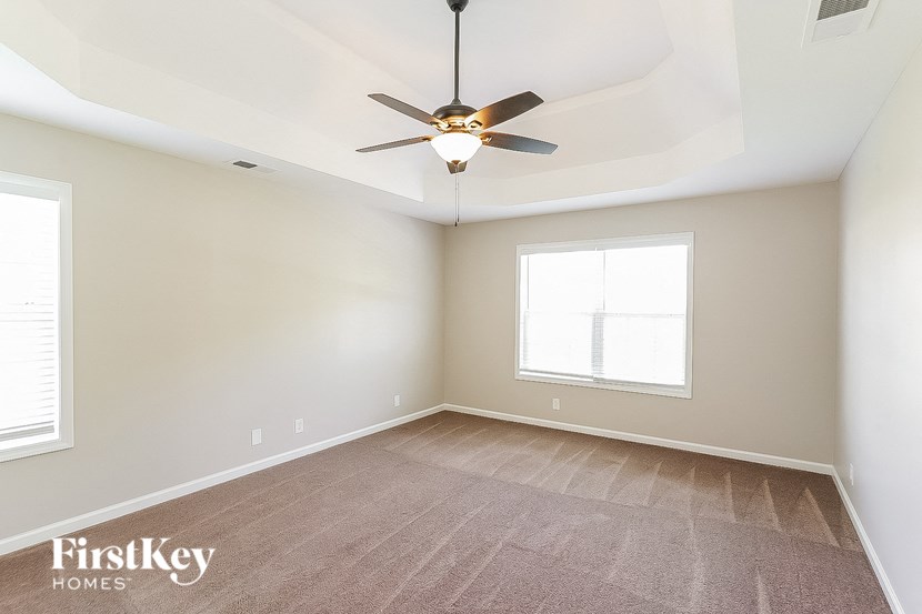 an empty room with a ceiling fan and a window
