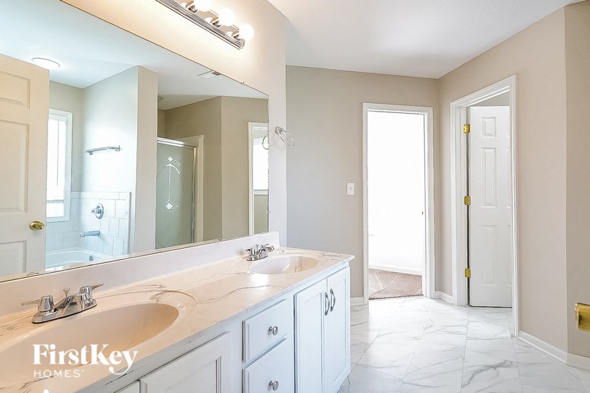 a white bathroom with two sinks and a large mirror