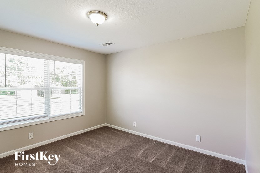 a bedroom with a large window and a wooden floor