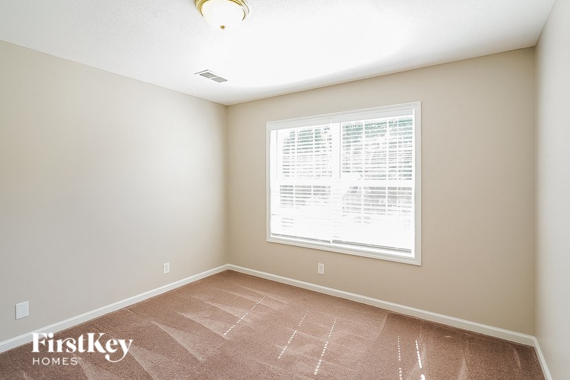 a bedroom with a large window and a tiled floor