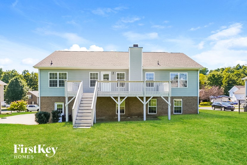 a blue house with a deck and a white staircase