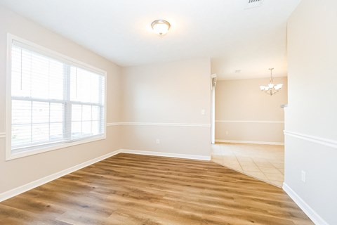 a living room with a large window and a wooden floor