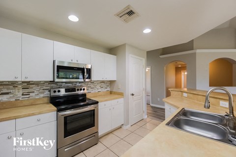 a kitchen with stainless steel appliances and white cabinets