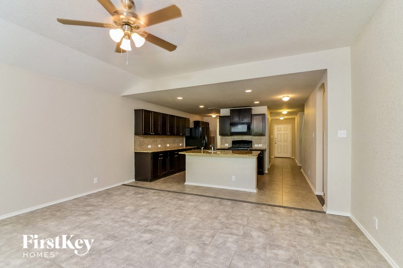 an open kitchen and living room with a ceiling fan