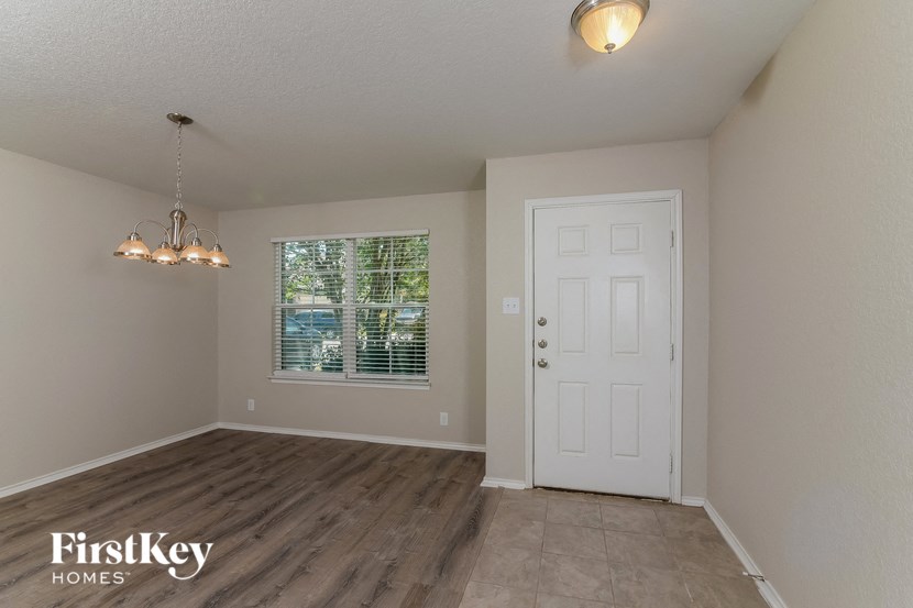 the spacious living room with a white door and a window