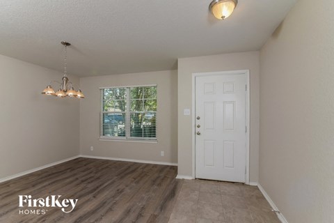 the spacious living room with a white door and a window