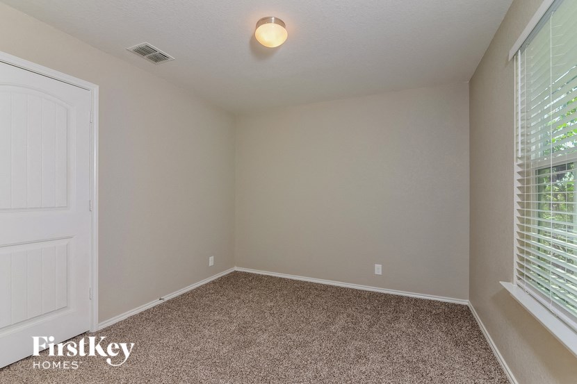 the bedroom has a carpeted floor and a large window