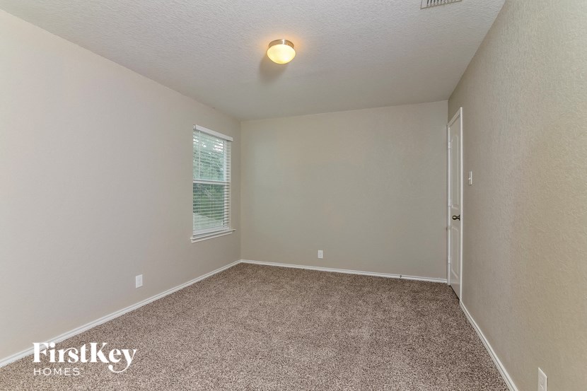 the upstairs bedroom has a carpeted floor and a window