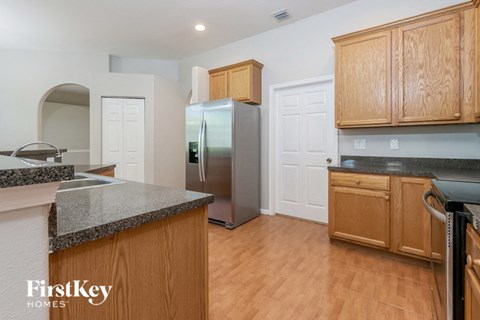 A kitchen with wooden cabinets and a granite countertop.
