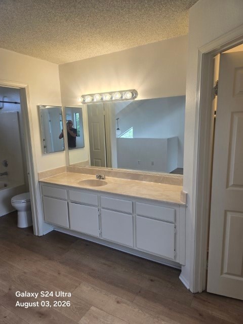 A bathroom with a white vanity and a mirror with lights above it.