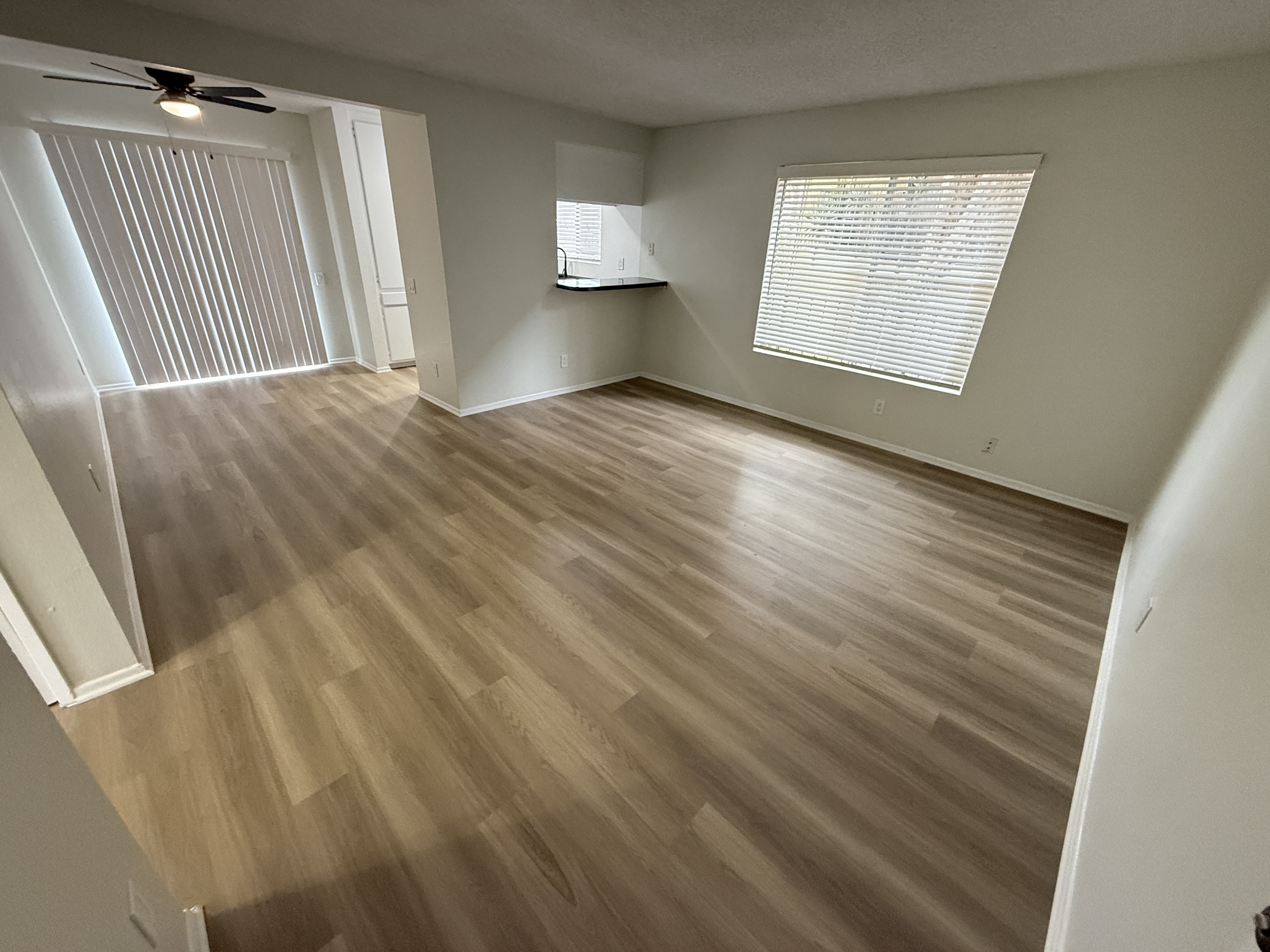 A room with wooden flooring and a ceiling fan.