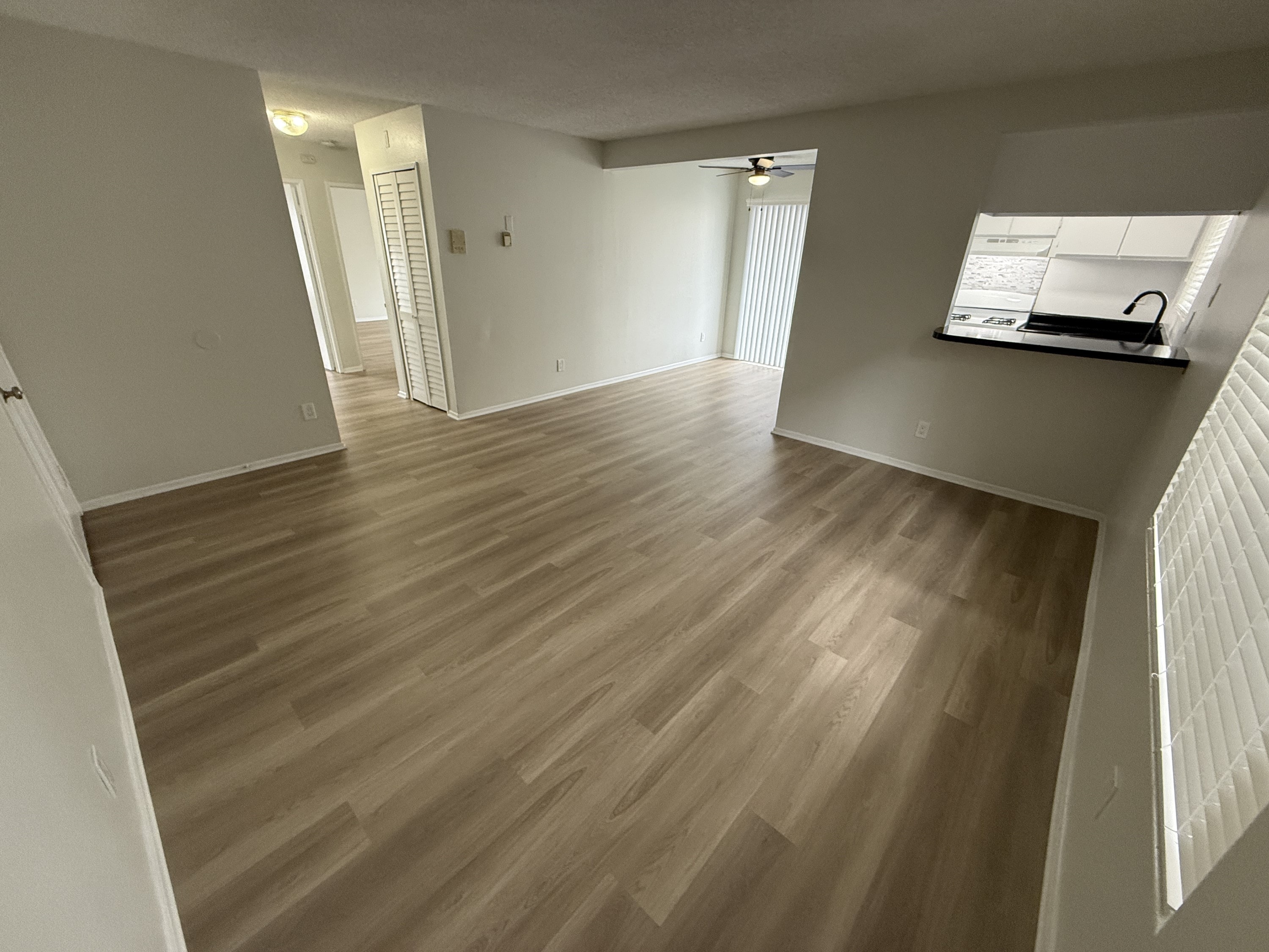 A room with wooden flooring and white walls.