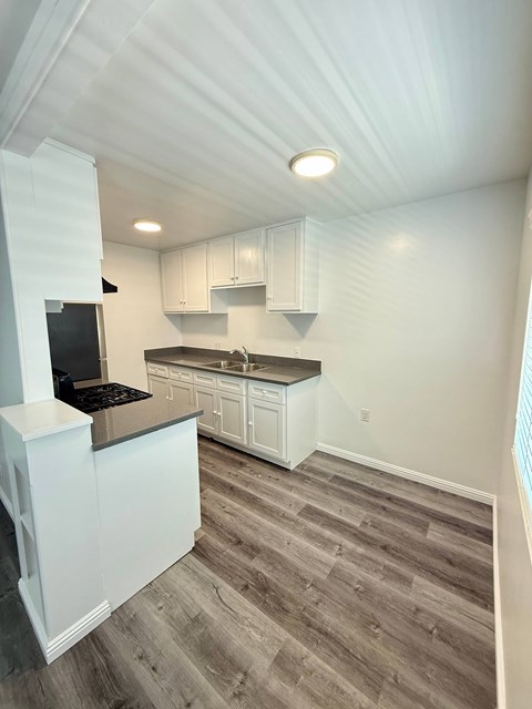 A kitchen with a white counter top and a black stove top oven.