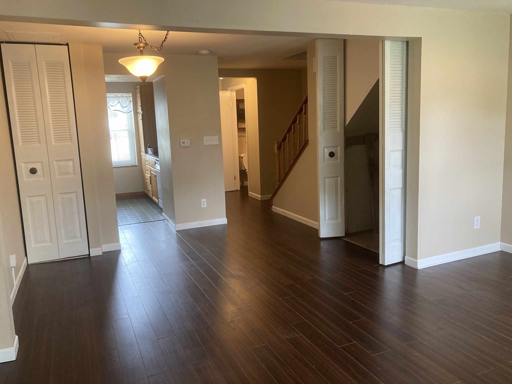 A hallway with wood floors and white walls.