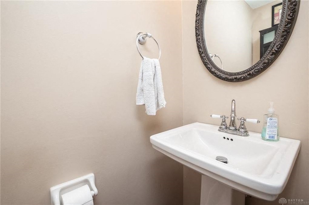 A white sink with a towel hanging on the wall.