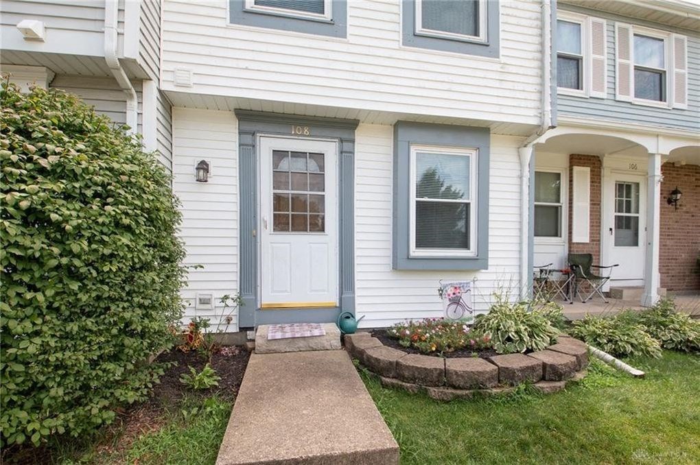 A house with a grey front door and a small garden in front.