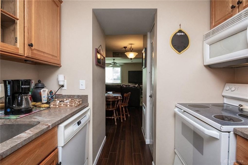 A kitchen with a white stove top oven and a white microwave above it.