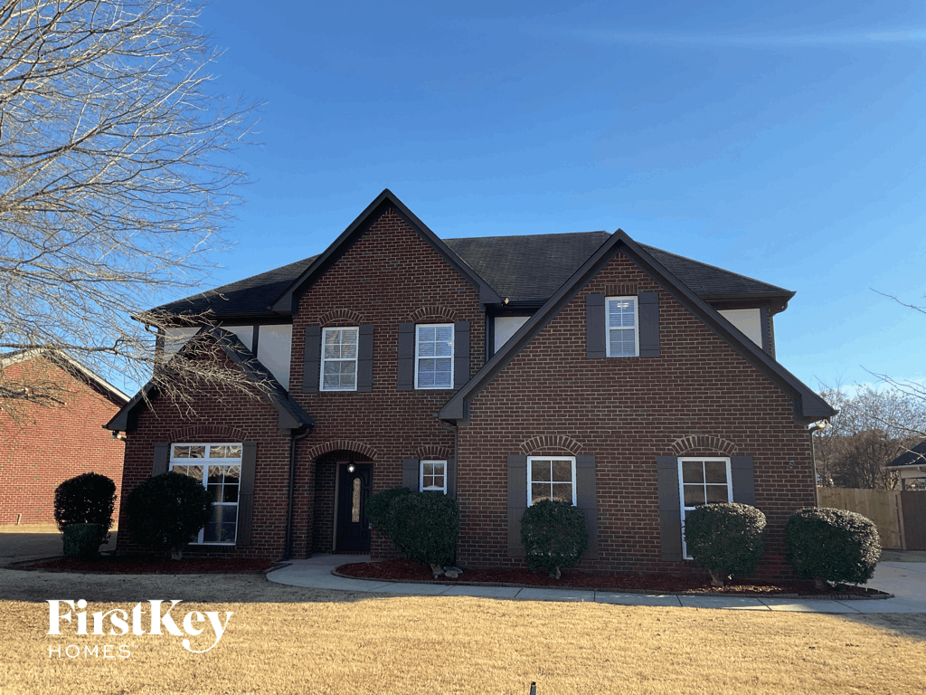 A brick house with a black roof and a clear blue sky in the background.
