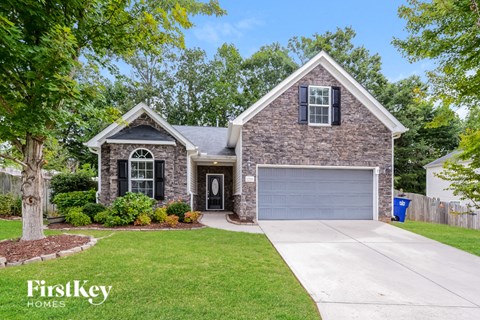A house with a garage and a driveway in front of it.