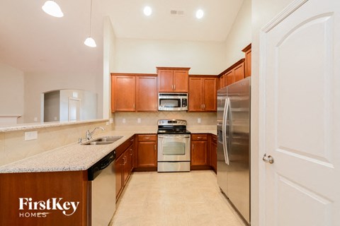 A kitchen with wooden cabinets and a refrigerator.