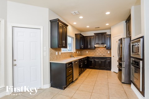 a kitchen with black cabinets and stainless steel appliances