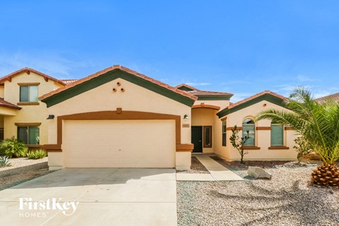a house with a garage and a palm tree in front of it