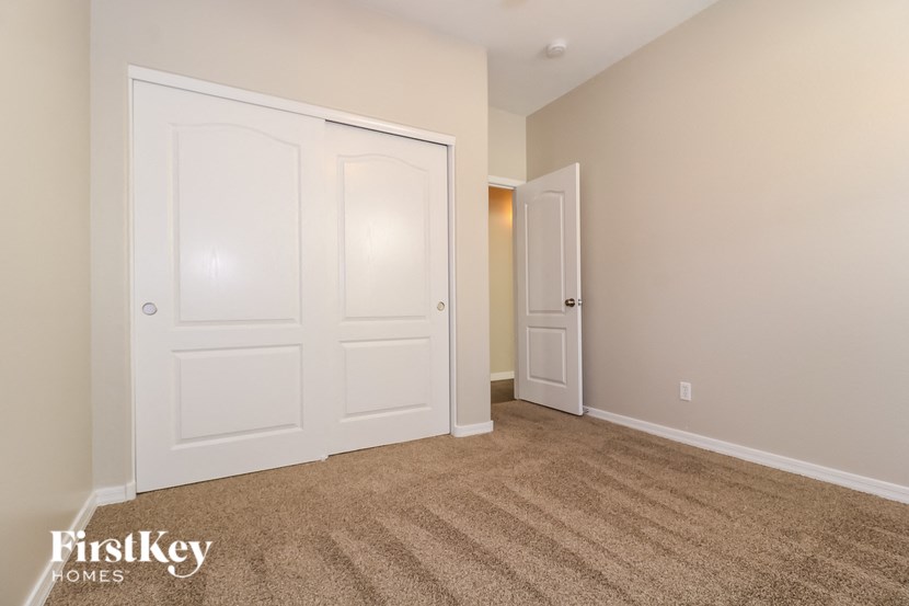 a bedroom with two closets and a carpeted floor