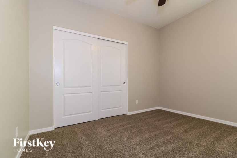 a bedroom with two closets and a carpeted floor