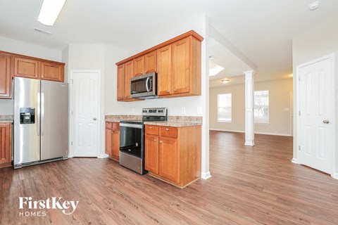 A kitchen with wooden cabinets and a stainless steel refrigerator.