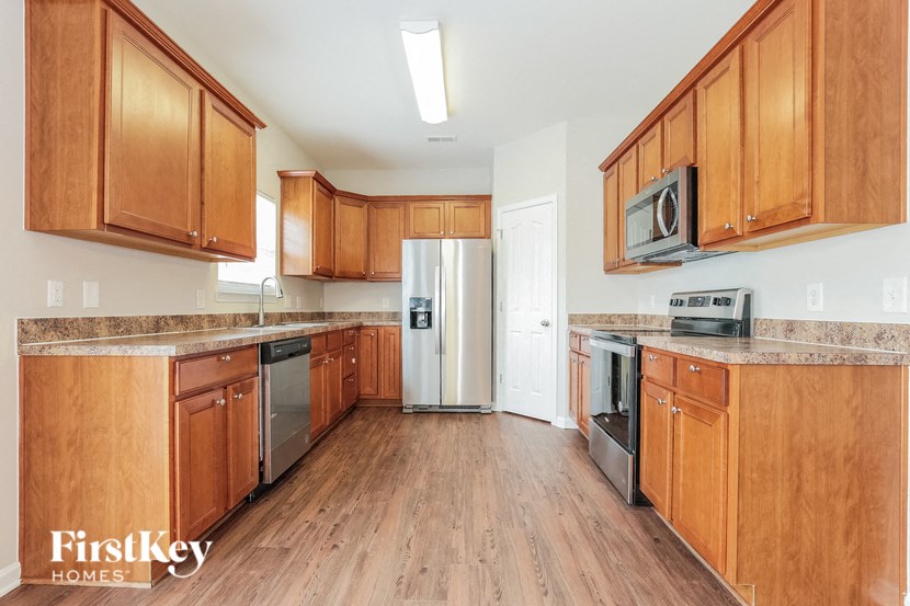 A kitchen with wooden cabinets and a refrigerator in the middle.