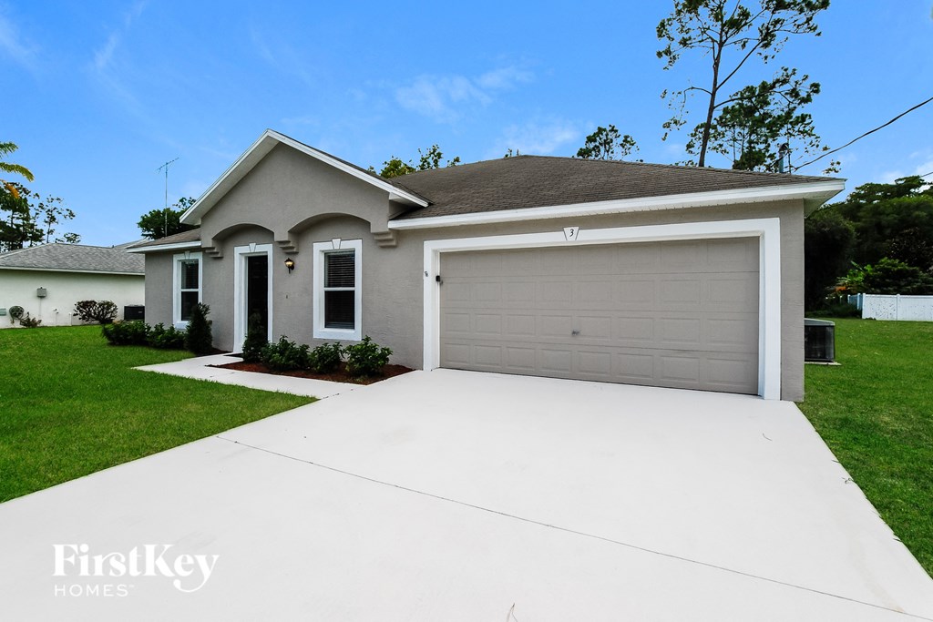 a white driveway in front of a house with a garage door