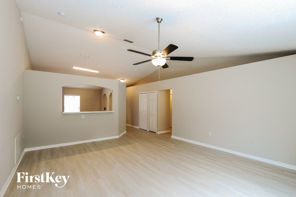 a living room with a ceiling fan and a white wall